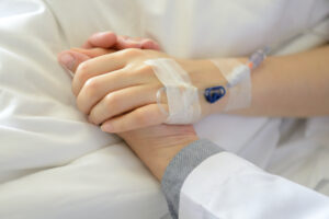 Medical doctor holing patient's hand and comforting her