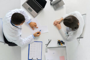 doctor with prescription and patient at hospital