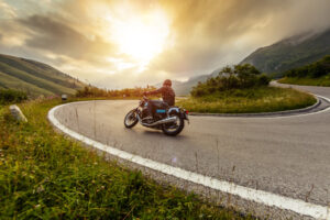 Motorcycle driver riding in Alpine landscape