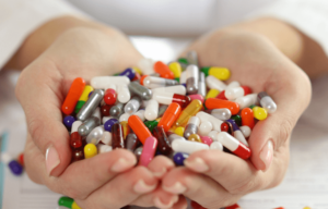 Pharmacist holding an assortment of prescription pills