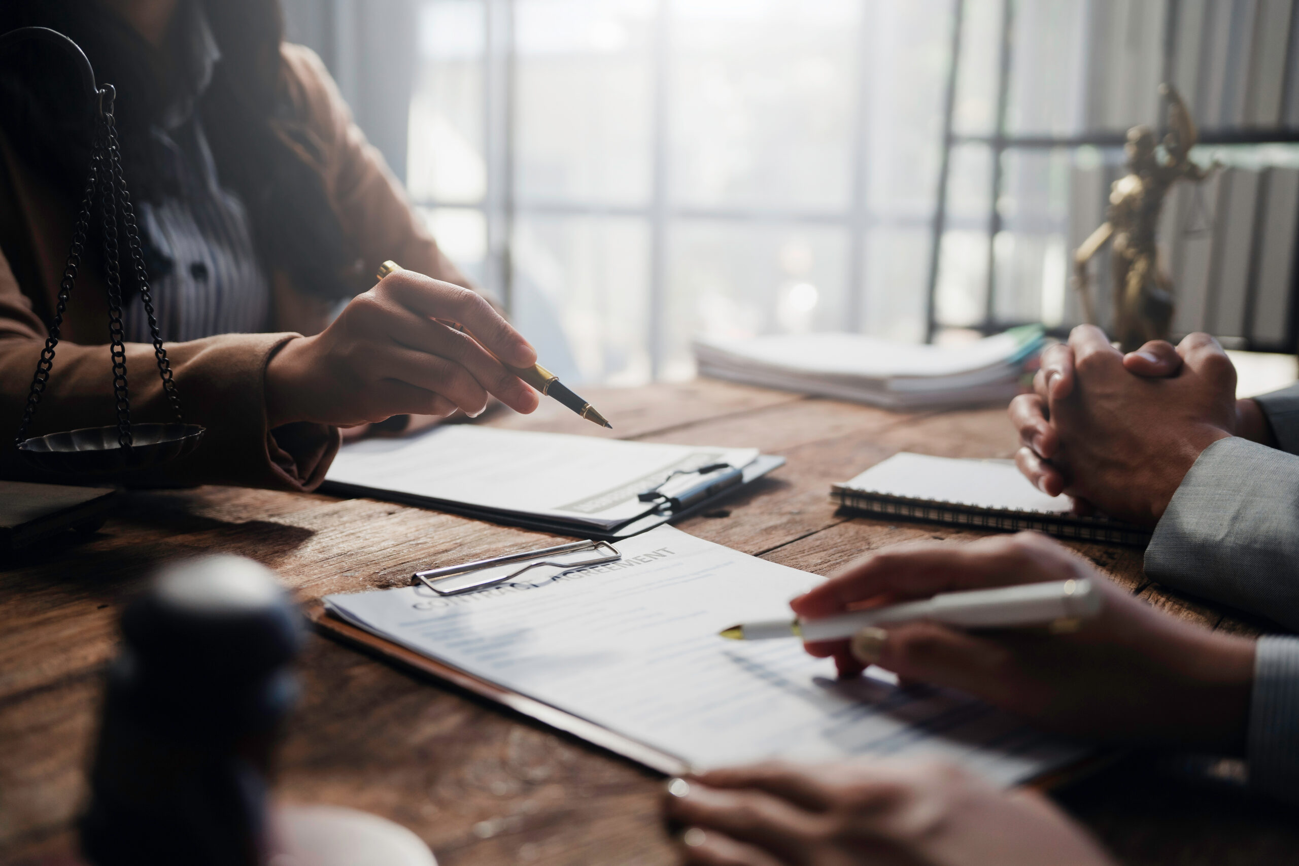 Lawyers and clients engaging in a detailed discussion about contract specifics during a focused meeting in a professional law office