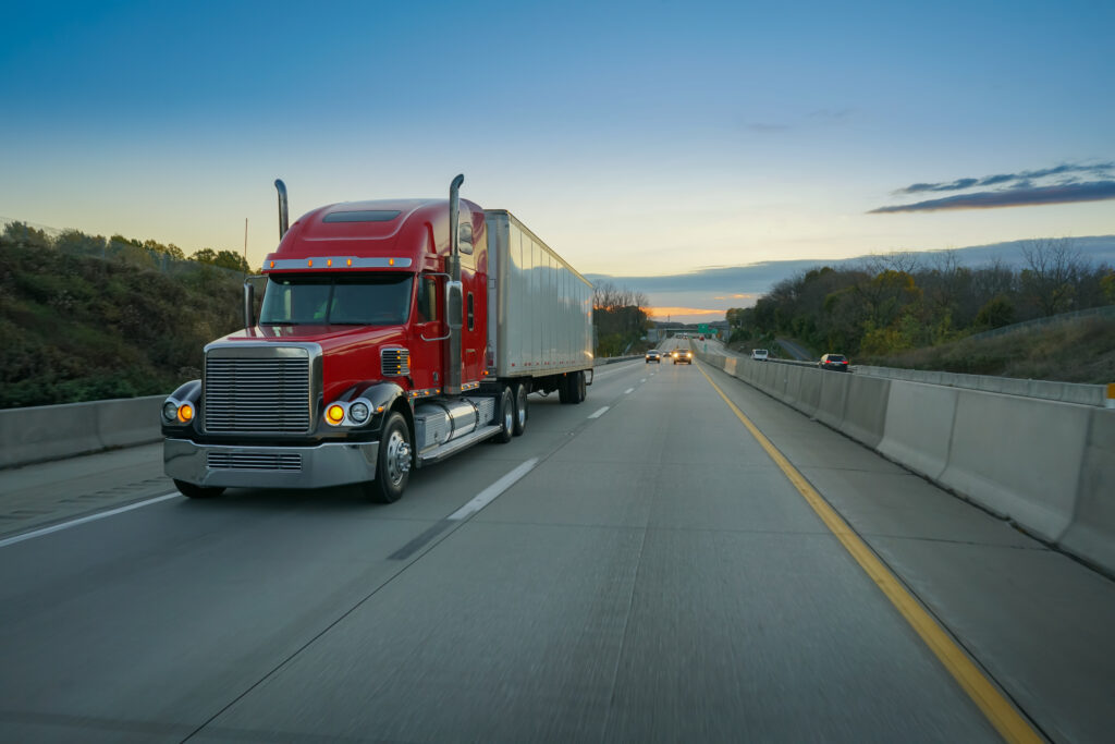 Semi truck on highway at sunset