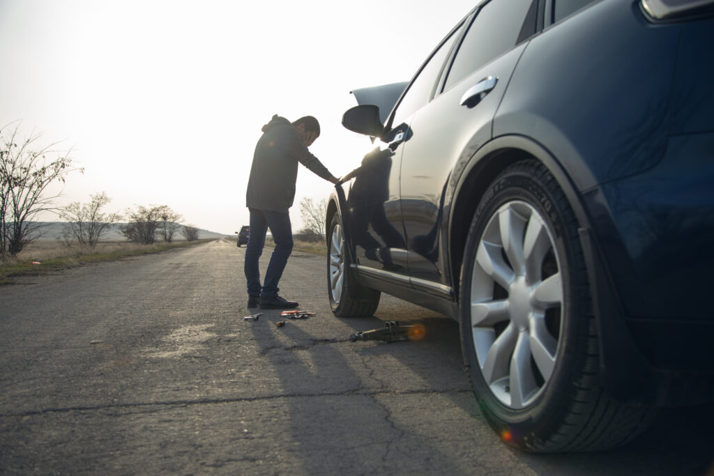 man and defective car in the street