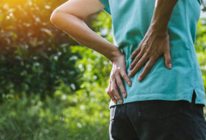 Closeup hands of woman touching her back pain in healthy concept